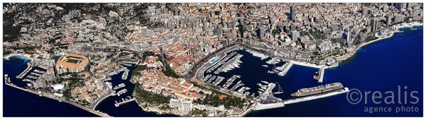 Vue panoramique aérienne de Monaco. Au premier plan le rocher, à droite le port Hercule, à gauche le port de fontvieille et le stade Louis II.