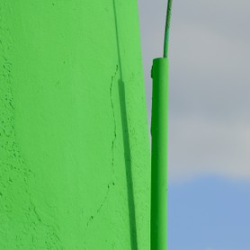 Blitzableiter an grünem Leuchtturm mit blauem Meer, Detailaufnahme