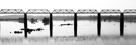 India Follows Raabe 12 - Das Schwarzweißbild zeigt die Strukturen einer Brücke über den Ganges in Indien mit kleinen Inseln im Fluss. Die Grafik der Brücke zeigt ihre Anatomie.