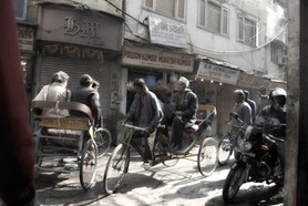 India Follows Raabe 27 - Blick in das Leben einer Straße von Dehli. Rikschas neben Motorrädern unter einem Gestrüpp von Stromkabeln. Das alte und das neue Indien begegnen sich.