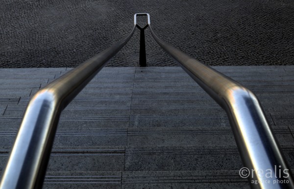 No exit - Die Eisenrohre eines Geländers über einer grauen Treppe geben dem Bild durch ihre geschlossene Form eine dramatische Wirkung